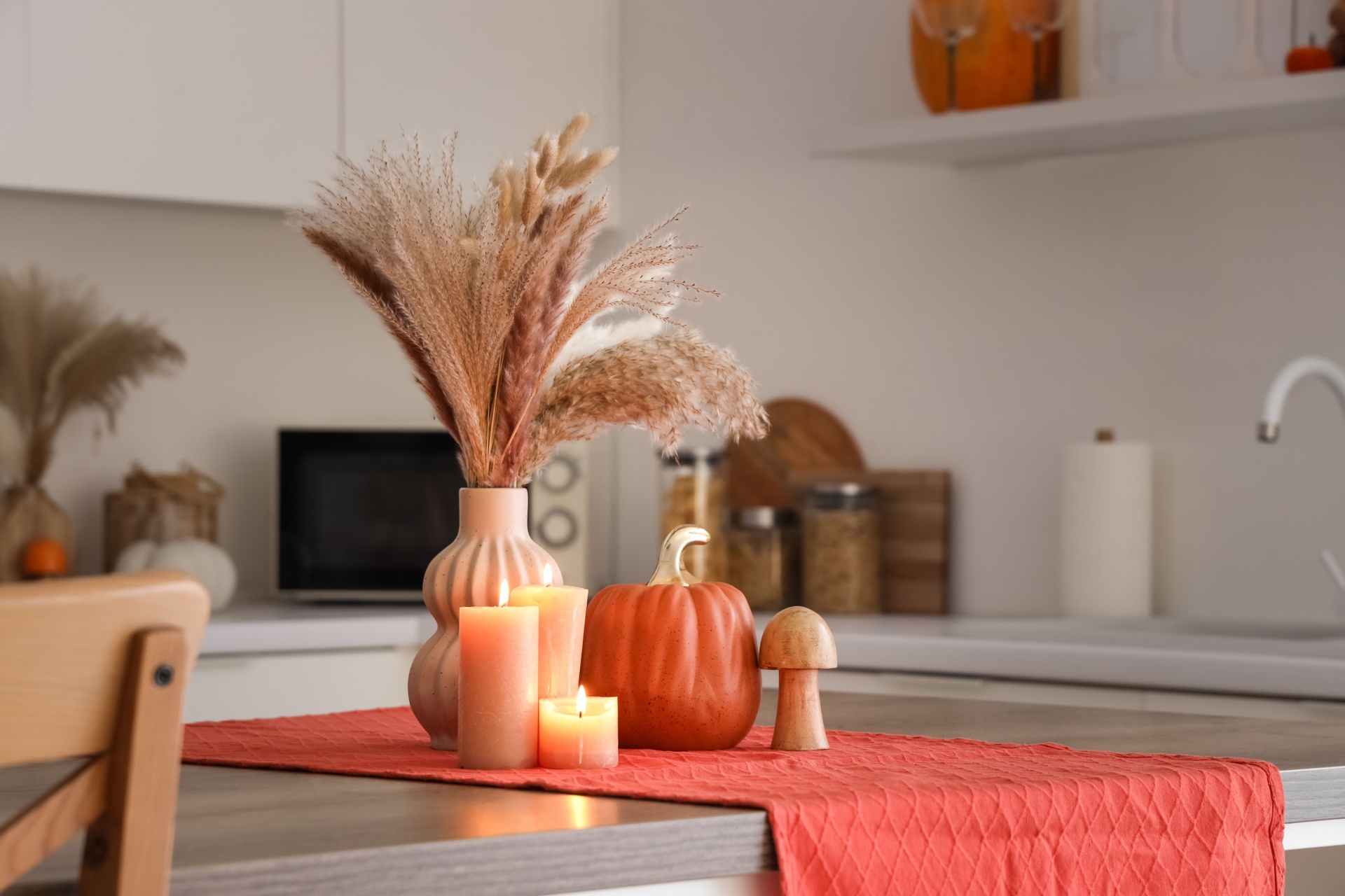 Høstblomster plassert på en kjøkkenbenk sammen med høstdekor